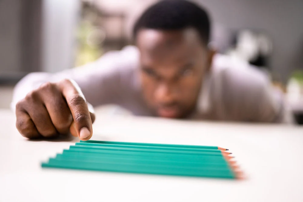 a man with ocd lining up the pencils
