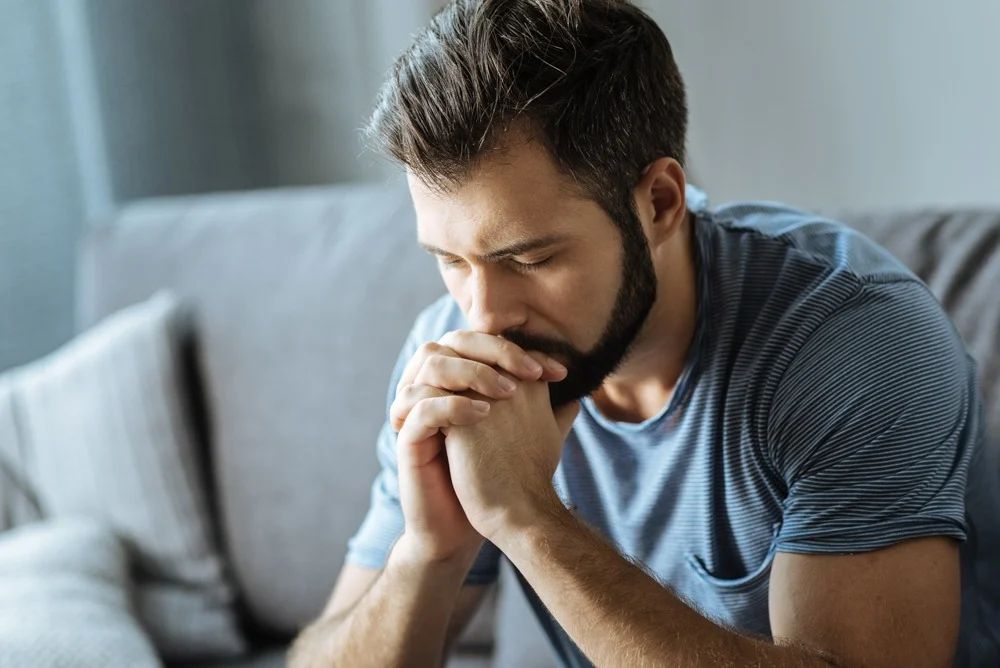 a man with eyes closed praying