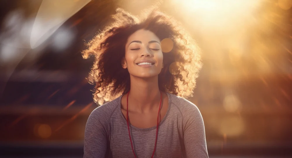 a woman smiling with eyes closed in sunlight