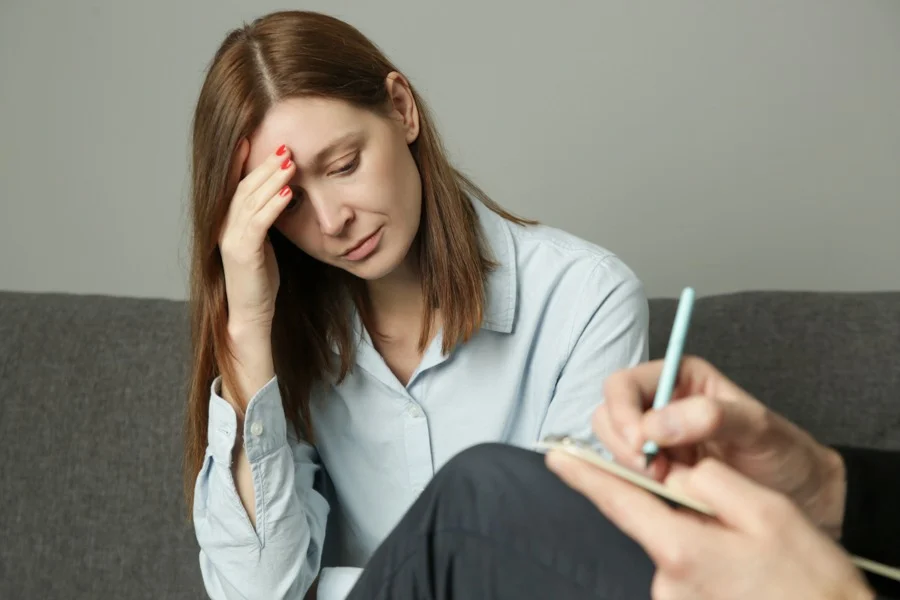 a woman with hand on face sad sitting in therapy