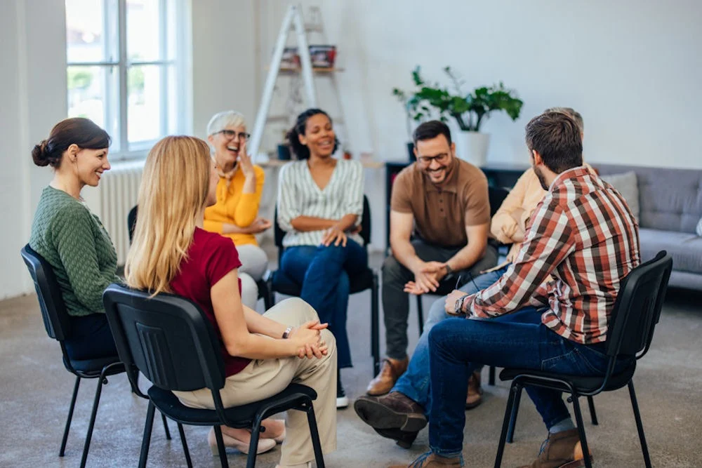 individuals laughing in group therapy