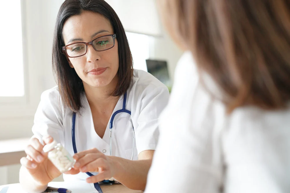 a doctor showing pill instructions to patient