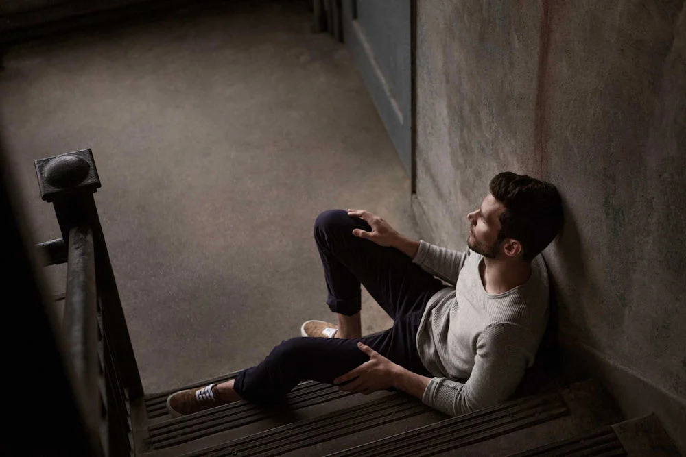 man sitting on stairs experiencing fentanyl patch side effects