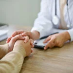 addiction specialist touching the hand of a patient