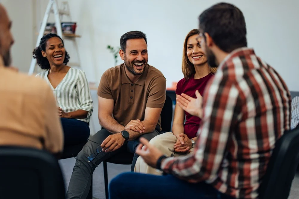 a man laughing in group therapy