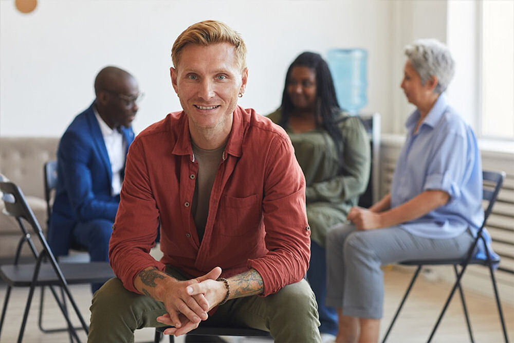 man smiling during group therapy