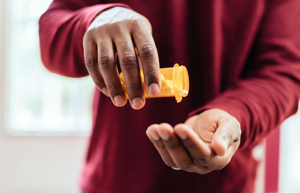 a-man-pouring-pills-into-hand