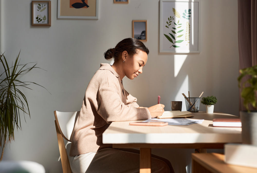 a woman writing on her journal