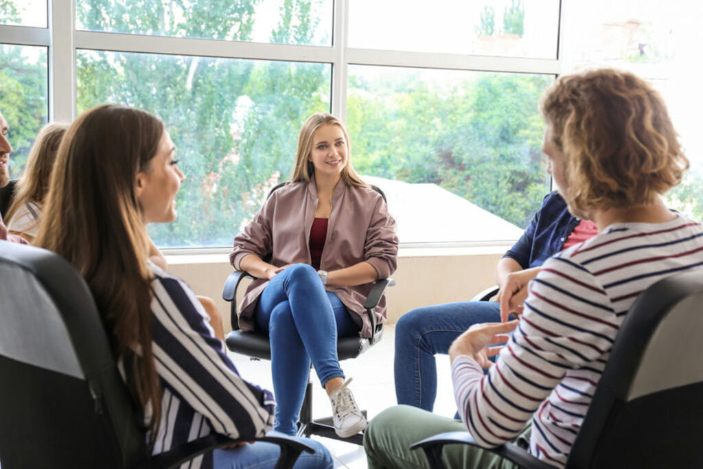 a-woman-smiling-in-group-therapy