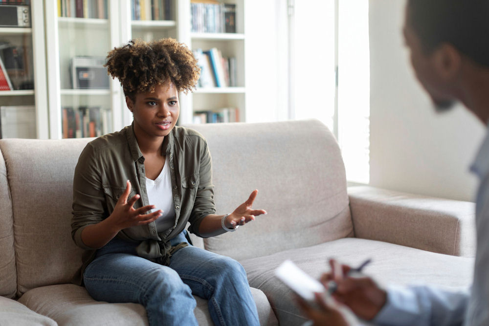 a-woman-with-her-hands-raised-up-in-individual-therapy