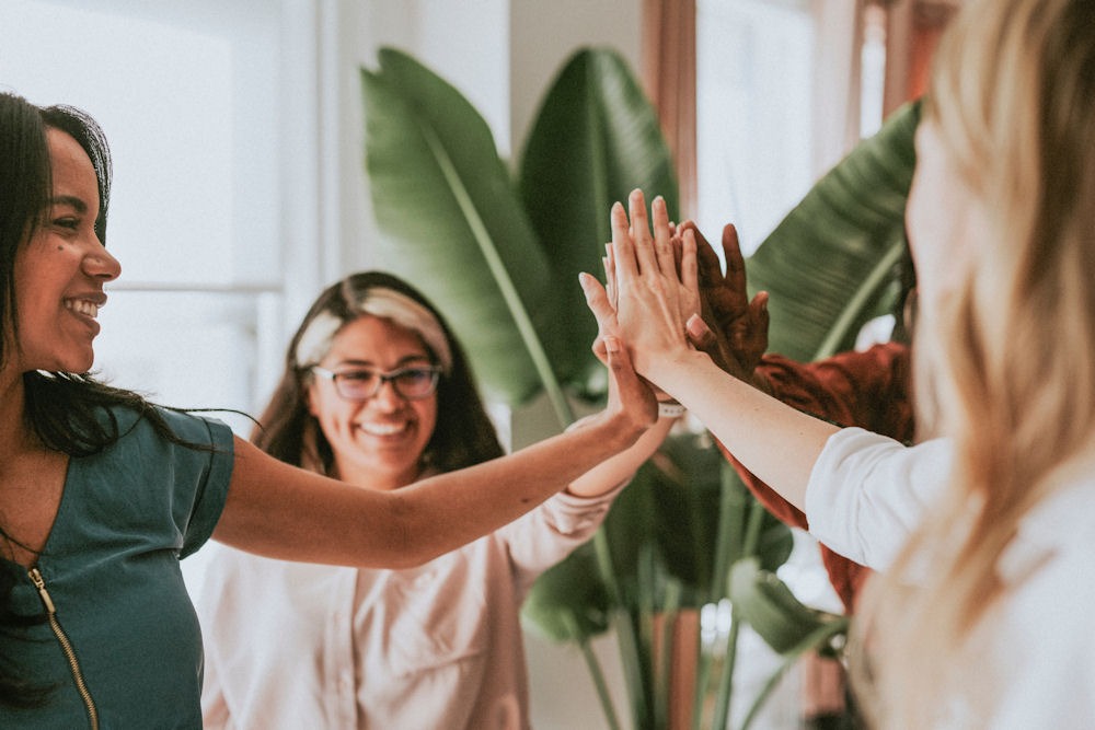 a-group-of-women-putting-hands-together