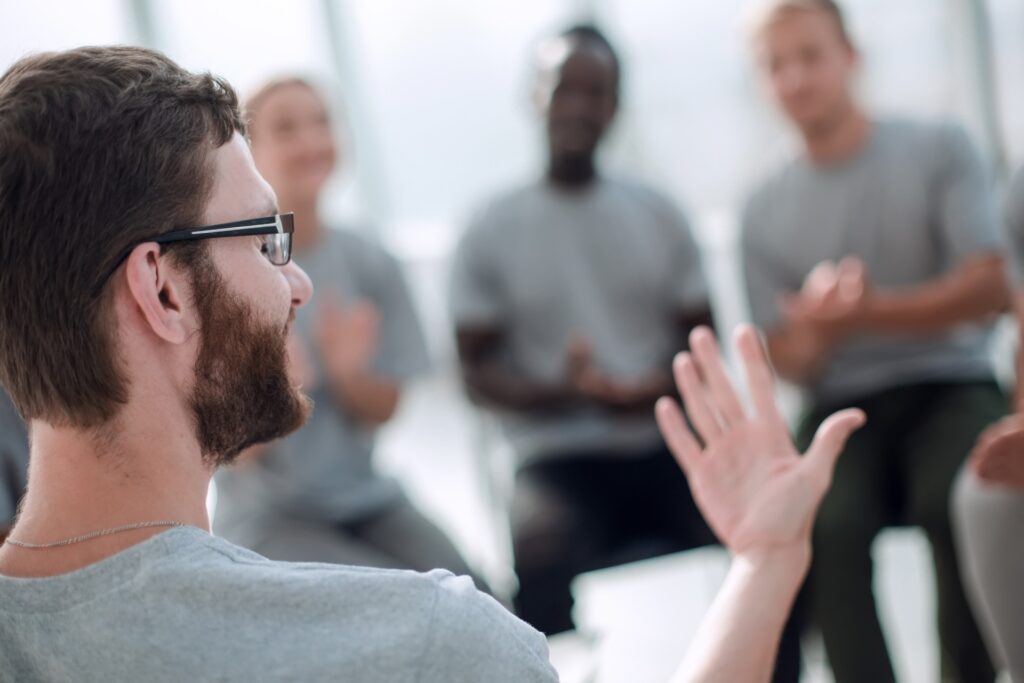 man talking in group therapy for addiction