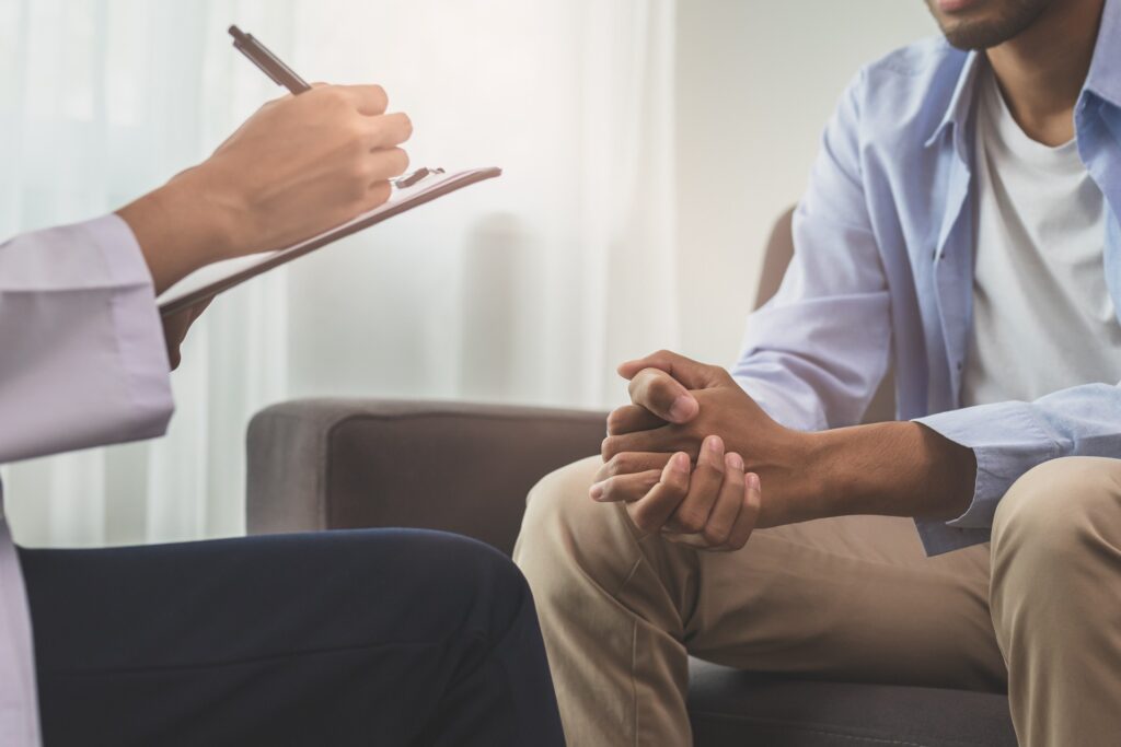 a man sitting in a therapy session at a rehab