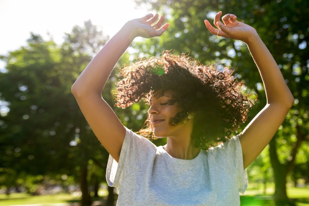 a woman dancing in the sunlight