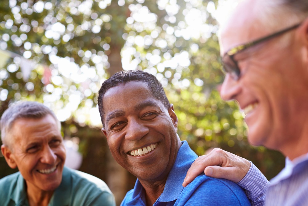 a man being comforted in a support group oustide