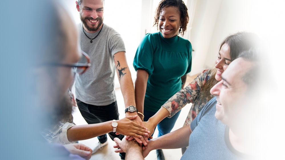 a group of sober friends joining hands