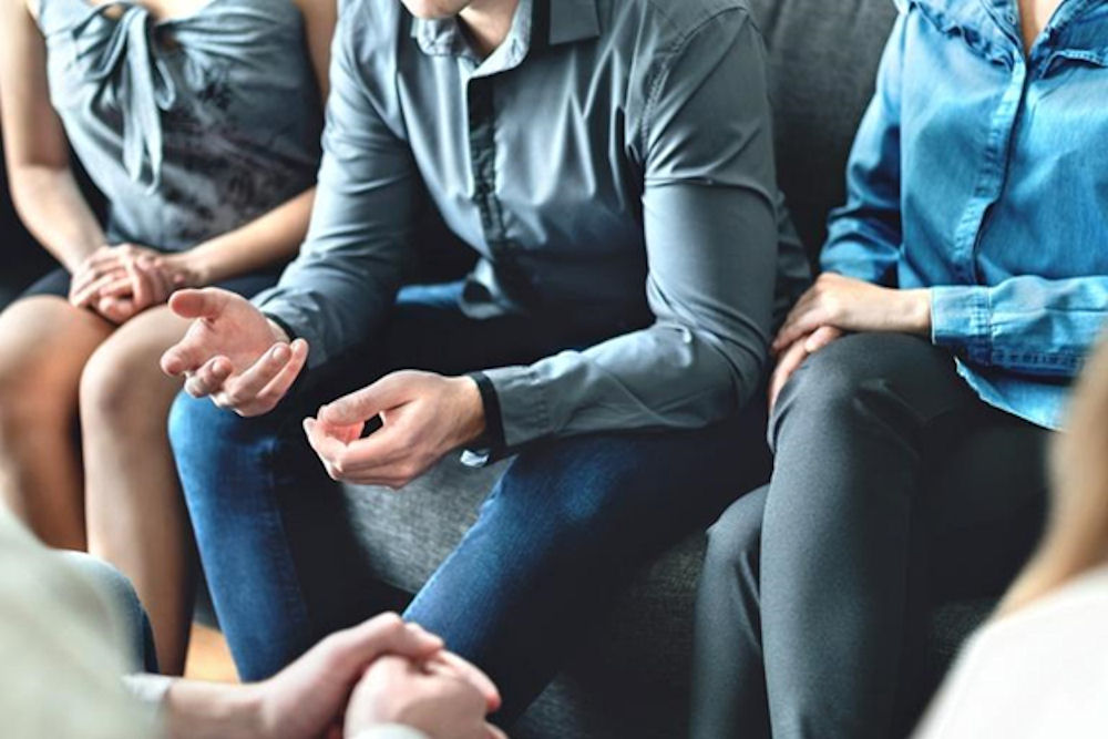 Individuals sharing experiences during stimulant rehab group therapy