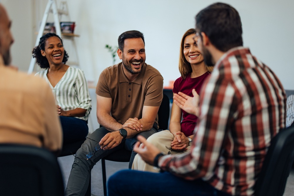 a man laughing in group therapy