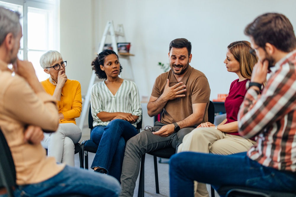 a man speaking in group therapy