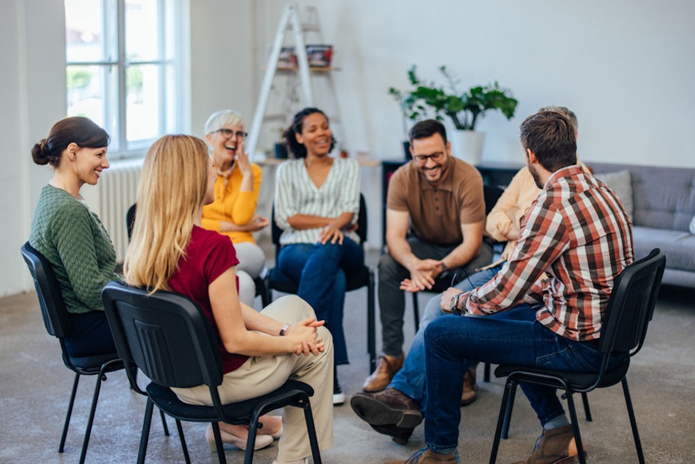 individuals laughing in group therapy