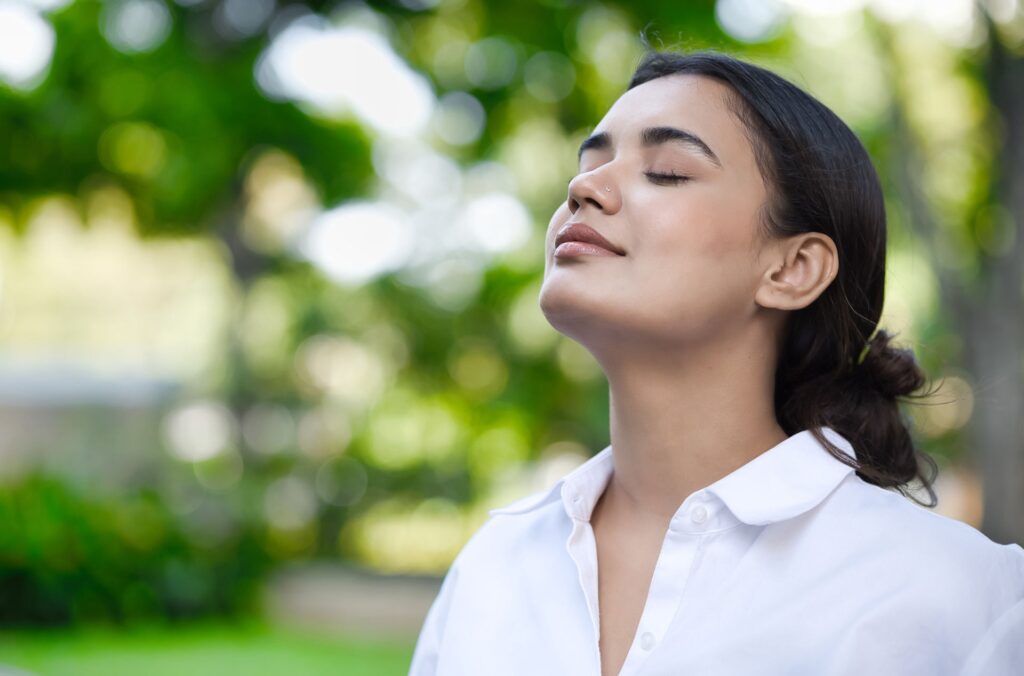 A woman enjoying the fresh air outdoors, reflecting on the benefits of being sober.