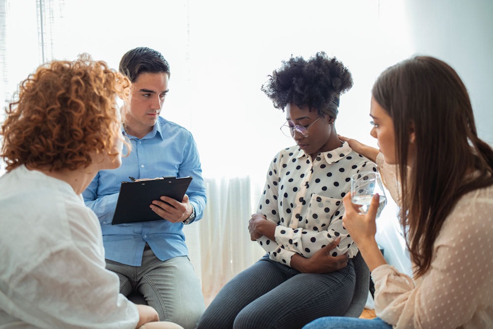 a woman being comforted in group therapy