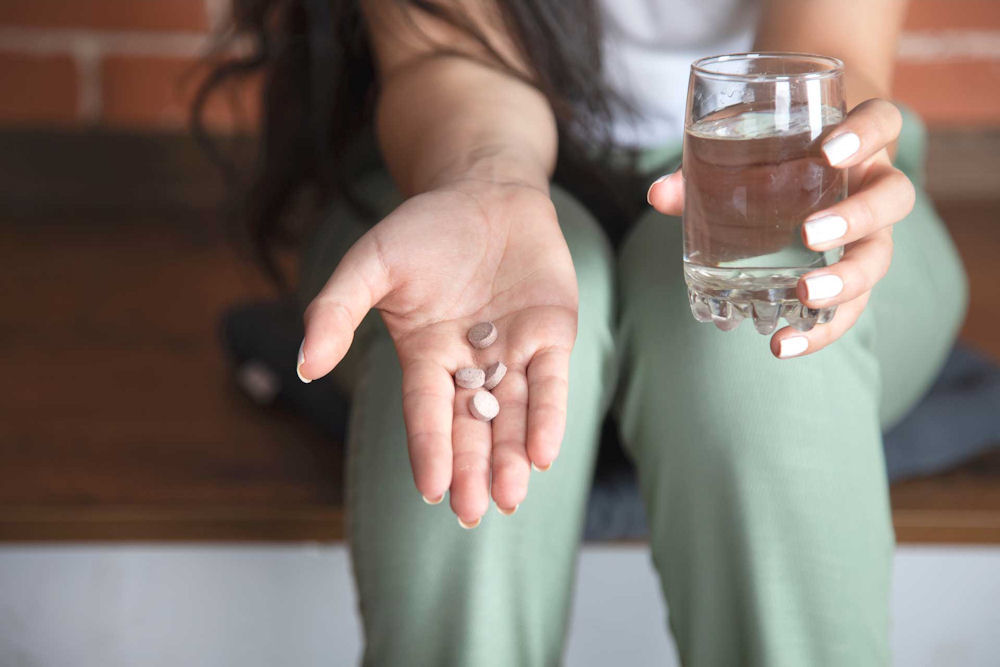 a-woman-holding-pills-in-her-hand